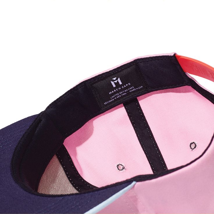 The Blinky is a classic six-panel, baseball-style cap in pink with a contrasting light blue brim and raised embroidery detail in orange. All March Caps feature top eyelets and an adjustable snap-back closure. Each cap comes with a hand-numbered card signed by the designer. Pink Fitted Hat With Curved Brim, Pink Curved Visor Dad Hat For Summer, Pink Dad Hat With Curved Visor For Summer, Pink Trucker Hat With Curved Visor, Pink Curved Brim Dad Hat For Sports, Pink Dad Hat With Curved Brim For Sports, Pink Sporty Baseball Cap With Curved Visor, Pink Snapback Baseball Cap With Embroidered Logo, Sporty Pink Baseball Cap With Curved Visor