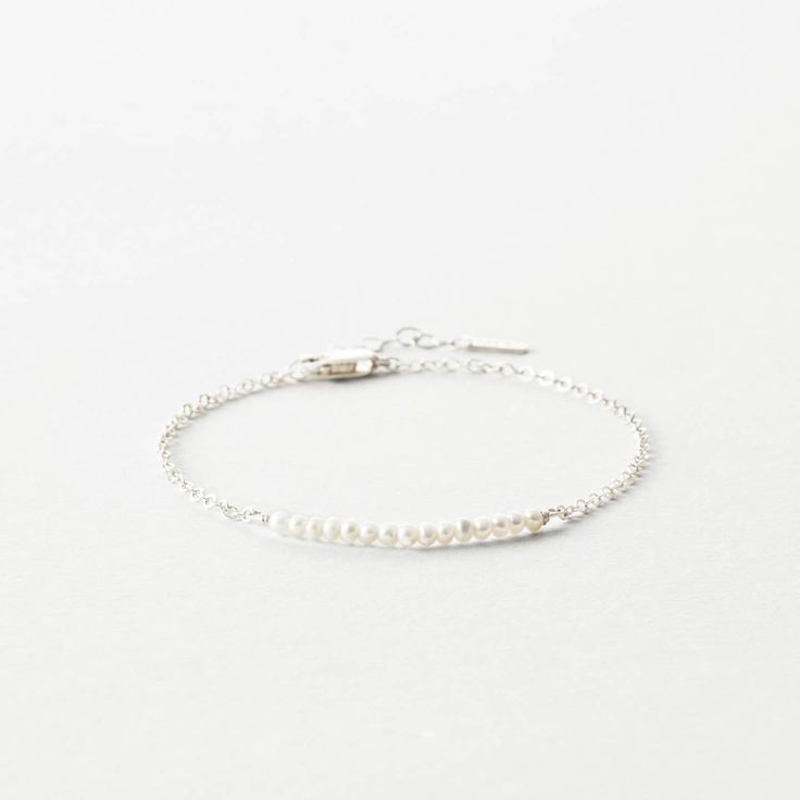 A delicate row of freshwater pearls is suspended on chain. Classic, subtle elegance for the win. Delicate Pearl Necklace With Tiny Beads For Everyday, Dainty Pearl Drop Bracelet, Dainty Pearl Drop Jewelry, Adjustable Everyday Pearl Chain Jewelry, Dainty Everyday Pearl Charm Jewelry, Minimalist Beaded Bracelets With Satellite Chain For Everyday, Minimalist Everyday Jewelry With Pearl Charm, Delicate Adjustable Pearl Bracelet, Adjustable Sterling Silver Pearl Drop Bracelet