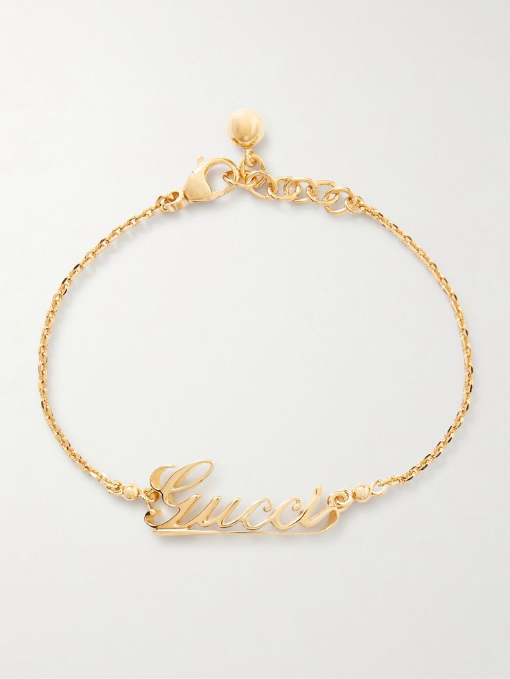 Gucci's bracelet is the perfect gift for a fan of the brand. It's been made in Italy from gold-tone metal and is centered with a script version of the house's moniker. Show it off with rolled cuffs or a sleeveless top. Yellow Gold Metal Jewelry With Gold-tone Logo, Luxury Gold-tone Jewelry With Logo Lettering, Luxury Gold-tone Jewelry With Logo Charm, Formal Yellow Gold Jewelry With Gold-tone Logo Lettering, Designer Yellow Gold Jewelry With Logo Lettering, Formal Yellow Gold Bracelets With Gold-tone Logo, Luxury Metal Jewelry With Logo Charm, Designer Gold Bracelets With Logo Charm, Modern White Gold Jewelry With Logo Charm