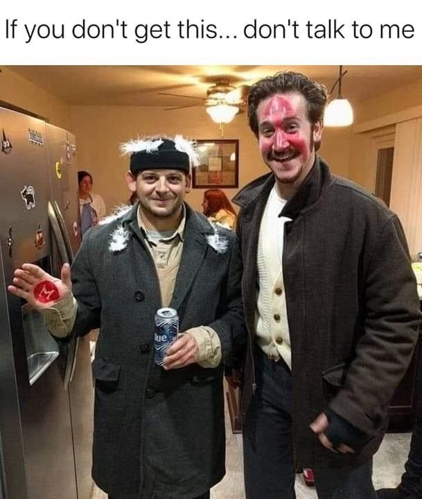 two men standing next to each other in front of a refrigerator with pink paint on their face