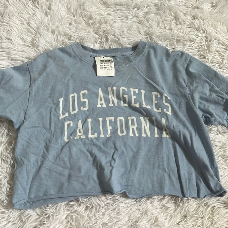 Brandy Melville Blue Los Angeles Cropped Tee. New With Tag. Trendy Light Blue Text Print Top, Blue Cotton Tops With Letter Print, Blue Cropped Graphic Tee With Letter Print, Blue Cotton Graphic Cropped T-shirt, Blue Graphic Cotton Cropped T-shirt, Blue Graphic Cropped T-shirt For Summer, Trendy Blue Cropped T-shirt With Letter Print, Blue Summer Top With Text Print, Trendy Blue Cropped T-shirt With Graphic Print