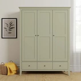 a gray armoire in a white room next to a basket and yellow blanket on the floor