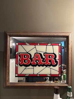 a bar sign hanging on the side of a wall