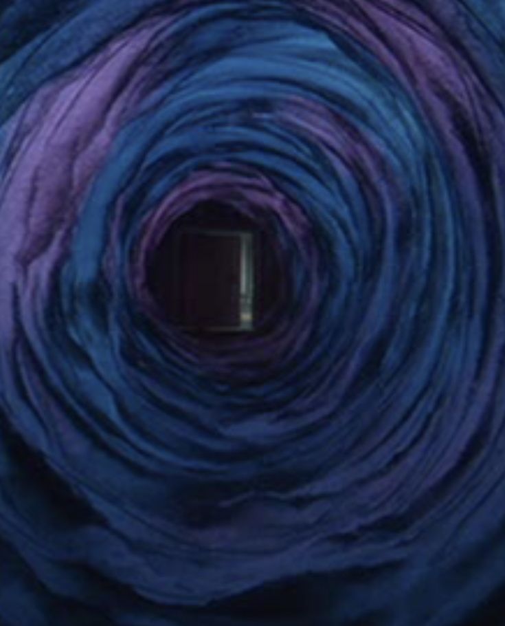 the inside of a blue and purple yarn ball with a window in it's center