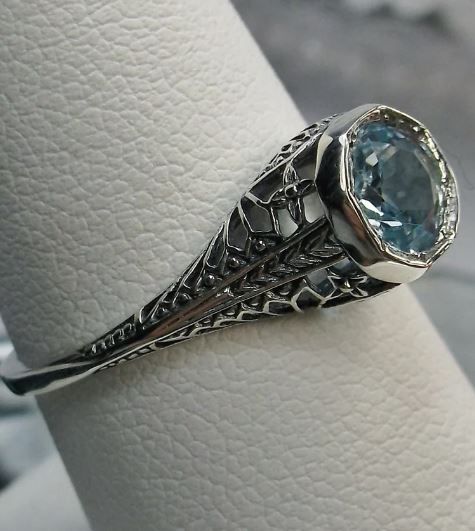 The approximately 1.5ct sky blue gemstone, of your choosing, is 6mm in diameter. This lovely ring is sterling silver and is marked 925 for sterling. Notice the beautiful craftsmanship of the silver & filigree setting and band. This is an ornate and detailed ring. This is a lovely rendition of an Antique filigree ring, and it is ready to wear. A ring gift box is included and all rings are shipped in the box for safekeeping. Light Blue Emerald Cut Jewelry For Wedding, Emerald Cut Light Blue Jewelry For Weddings, Light Blue Emerald Cut Wedding Jewelry, Exquisite Blue Topaz Jewelry With Prong Setting, Silver Art Deco Aquamarine Rings, Art Deco Silver Aquamarine Rings, Wedding Jewelry With Light Blue Center Stone, Sapphire Solitaire Jewelry For Wedding, Light Blue Jewelry With Center Stone For Wedding