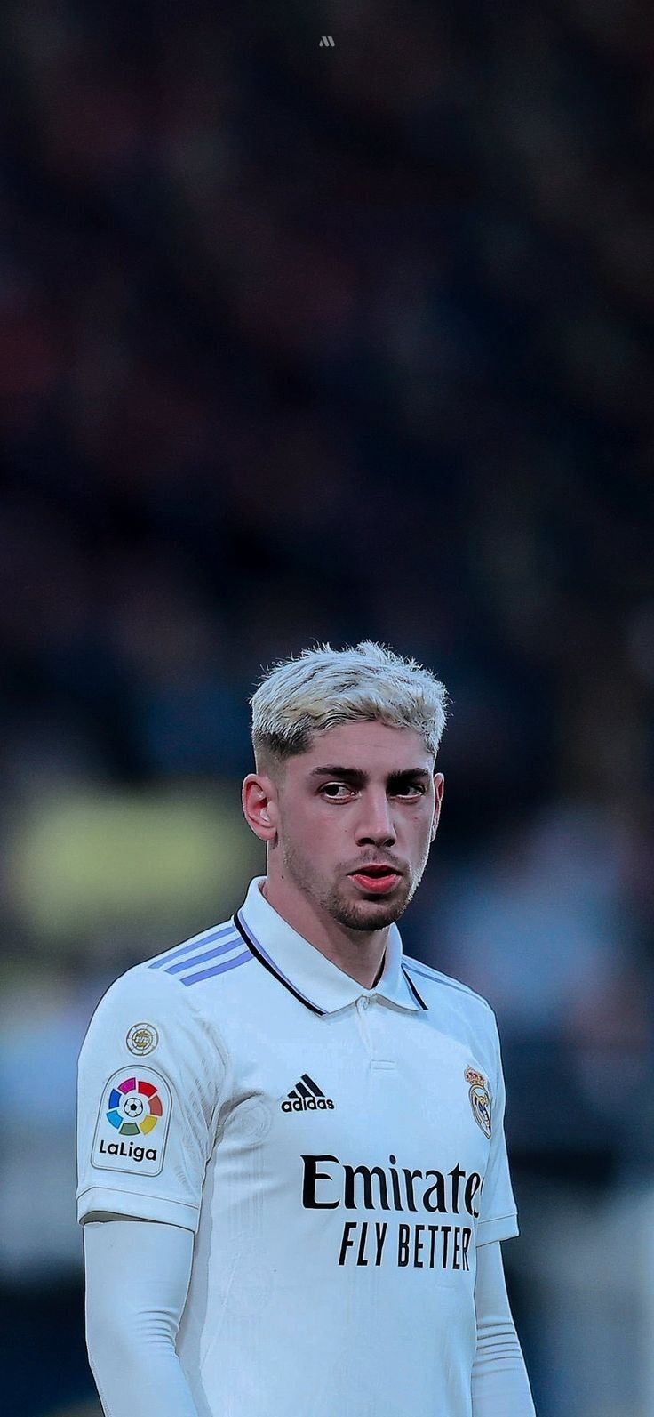 a soccer player is standing in front of the ball and looking at the camera with an intense look on his face