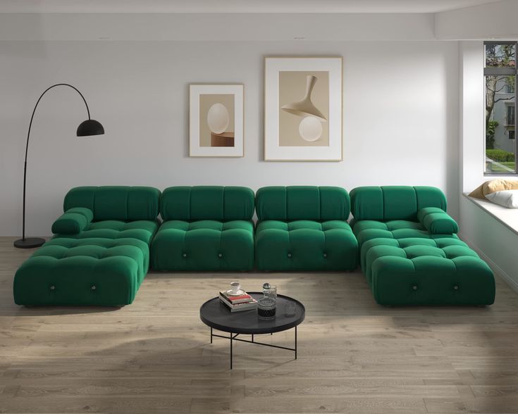 a living room with green couches and pictures on the wall