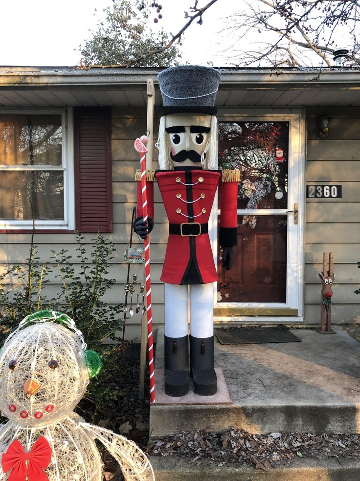 a large nutcracker standing in front of a house