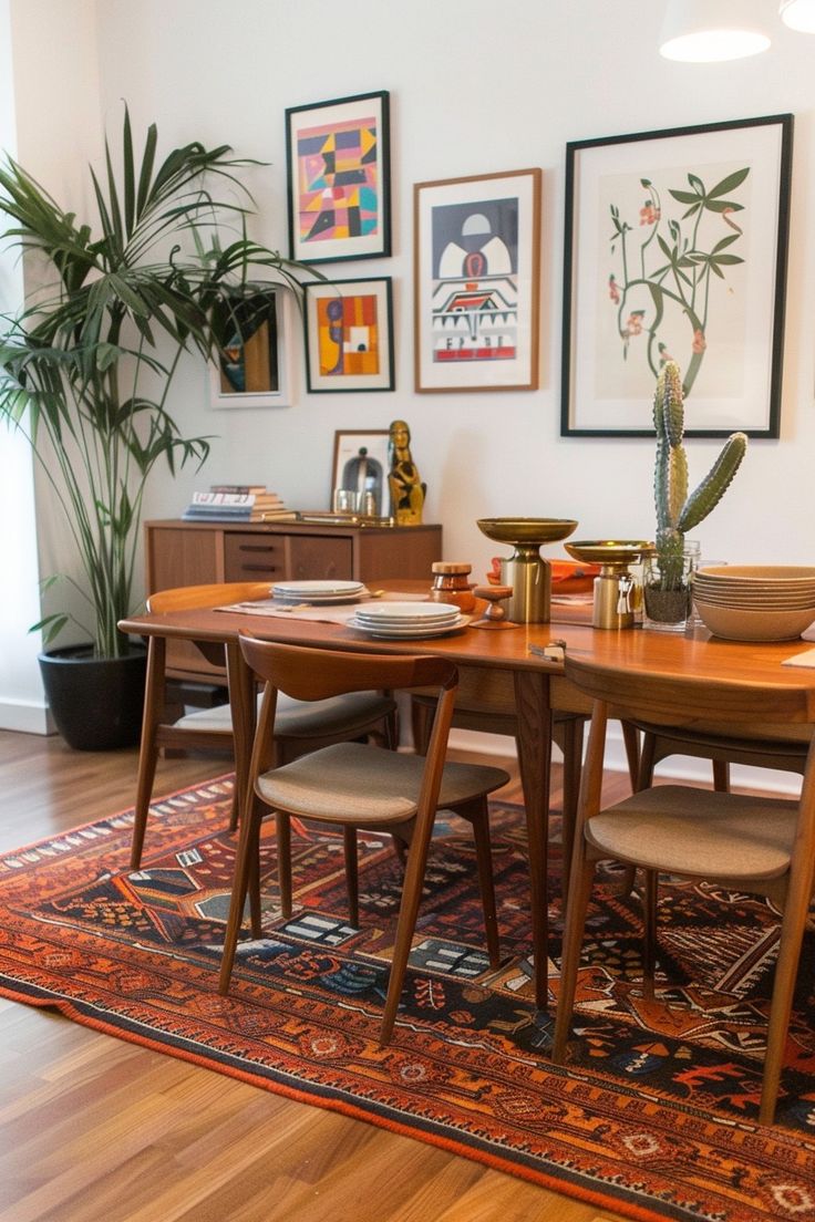 a dining room table and chairs in front of pictures on the wall with plants behind them