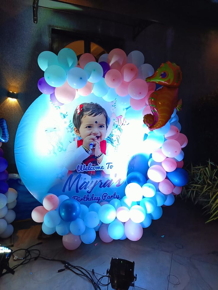 a balloon arch with an image of a baby on it