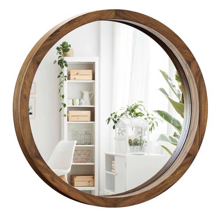 a round mirror sitting on top of a wooden shelf next to a white chair and potted plant