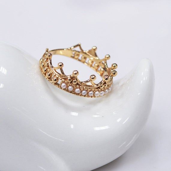 Holiday Notice: We will be on holiday from Feb 6 to Feb 15 for the Spring Festival. Orders will be shipped after we resume work.  Enchanted Crown Ring, Pearl Crown Wedding Ring, Tiara Crown Ring, Pearl Stackable Ring, Victorian Crown Ring, Crown Wedding Band Gold, Gifts Features• Made to Order. • Material: 925 Silver with Gold Plated• Gold Color: Yellow Gold• Stone Type: Pearl• Ring Size: US 5 - 8• For the material option sterling silver, it means it’s made in sterling silver with gold plated on Wedding Jewelry With Crown Design, Elegant Crown Wedding Ring, Elegant Crown Shaped Wedding Rings, White Round Crown Design Jewelry, Gold Crown-shaped Diamond Ring, White Round Jewelry With Crown Design, Diamond Crown Jewelry For Wedding, White Crown Jewelry For Wedding, White Pearl Open Ring For Wedding