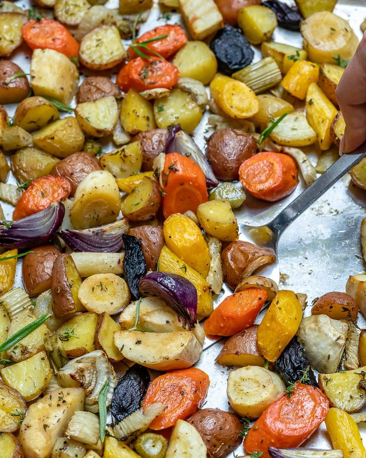 someone is cutting up vegetables on a sheet of tin foil with a spatula in front of them