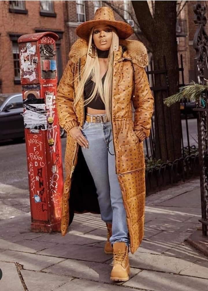 a woman walking down the street wearing a coat and hat