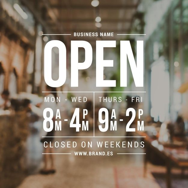 an open sign is displayed in front of a store window with people walking through it