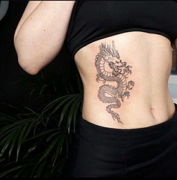 a woman with a dragon tattoo on her stomach