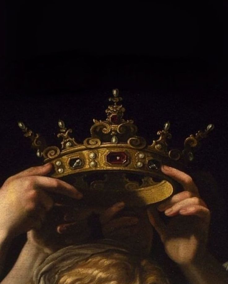 a person holding a crown over their face