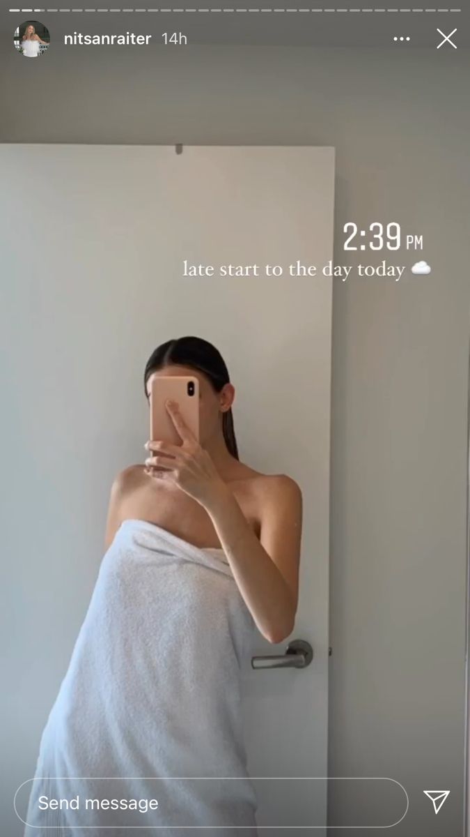 a woman taking a selfie in front of a mirror with the time on her phone