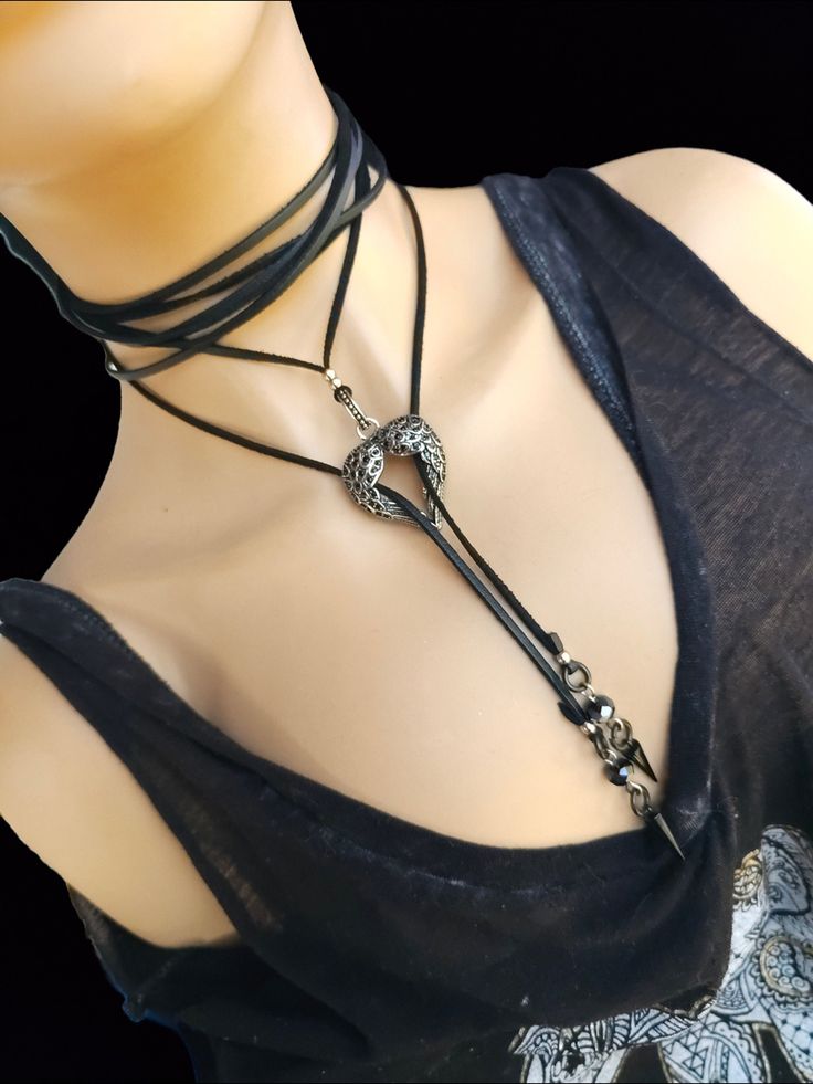 This gothic bolero style wrap Lariat choker necklace is black leather cord with stainless steel spike drop pendants hung from faceted obsidian beads. The centrepoint is a winged heart with black rhinestones. A gorgeous handmade Edgy Punk  aesthetic Jewelry Gift for Her!  Also available in blank steel chain instead of leather in our shop! Search "bolero". This is leather cord with stainless steel spikes, oxidized black. It can be wrapped in many different ways as shown.   ☝ Follow us on social me Adjustable Gothic Choker For Alternative Fashion, Festival Lariat Choker Necklace With Adjustable Length, Festival Adjustable Lariat Choker Necklace, Gothic Metal Choker For Concerts, Gothic Choker For Concert, Adjustable Punk Choker For Alternative Fashion, Edgy Black Choker For Festivals, Silver Gothic Choker For Concert, Gothic Choker Necklace For Alternative Fashion