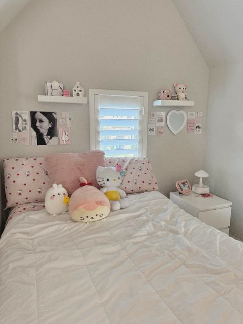 a white bed topped with pillows and stuffed animals