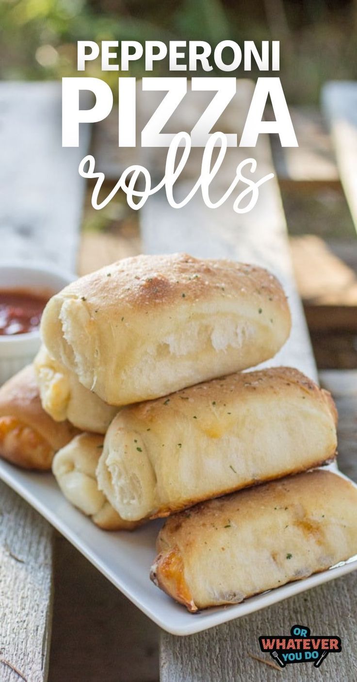 some pizza rolls on a white plate with ketchup and sauce in the background