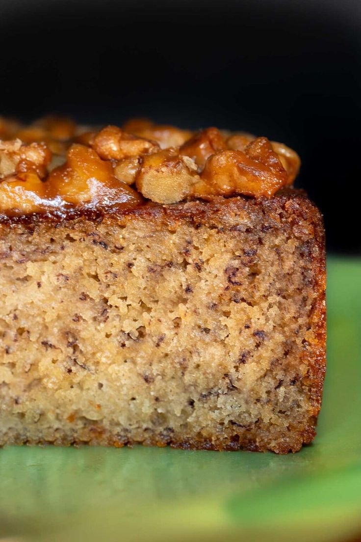 a piece of cake sitting on top of a green and yellow plate with nuts in it