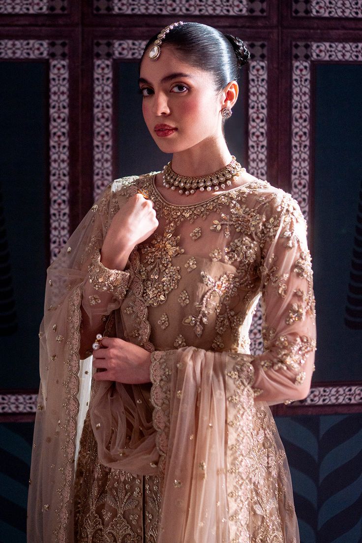 Brand: NeeshayCollection: Neeshay Parinaaz Unstitched Wedding Formal CollectionFabric: Net PRODUCT DETAILS: Net Embroidered And Hand Embellished Front Body (1 Pc) Net Embroidered And Hand Embellished Back Body (1 Pc) Net Embroidered And Hand Embellished Sleeves (0.66 M) Net Embroidered And Hand Embellished Sleeves Motif (2 Pcs) Net Embroidered Front Kalian (9 Pcs) Net Embroidered Back Kalian (9 Pcs) Net Embroidered Dupatta (2 M) Net Embroidered Dupatta Pallu (2 Pcs) Plain Dyed Rawslik (5 Yards) Elegant Semi-stitched Wedding Dress With Traditional Drape, Transitional Wedding Dress With Intricate Embroidery, Elegant Sharara With Intricate Embroidery For Wedding, Traditional Formal Gown With Intricate Embroidery, Traditional Embroidered Wedding Dress, Traditional Gold Wedding Dress With Dupatta, Fitted Dresses With Intricate Design For Festive Occasions, Gold Floor-length Wedding Dress With Dabka Work, Gold Wedding Dress With Dabka Work