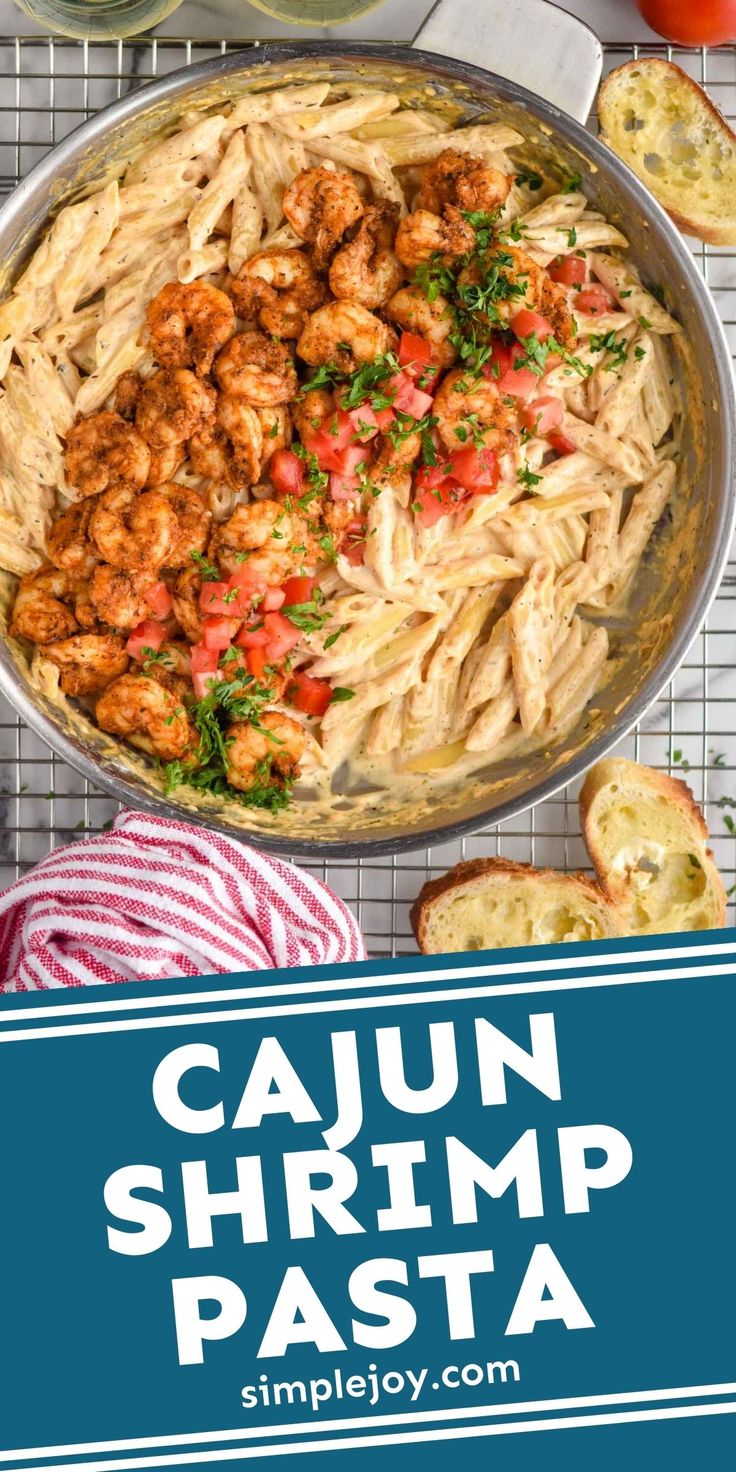 cajun shrimp pasta in a skillet with garlic bread and tomatoes on the side