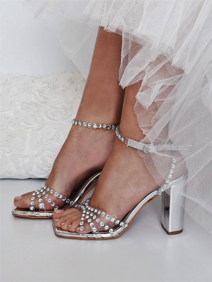 Our sandals have been made in Greece from silver leather and adorned with light-catching crystals that shimmer like a piece of jewelry. They're set on towering 100mm block stilettos. ♥ Colour: Transparent/ Silver ♥ Heel height: 10 cm (3.93 in) ♥ Sizing: Fits true to size, take your normal size ♥ If you need a rush delivery please let us know. ♥ Returns: The item(s) can be returned for refund within 10 days of the order's delivery date. In order for returns to be accepted, all items must be in perfect condition with security tag, original packaging and original invoice. In this case, you shall solely bear the immediate cost of returning the product. ♥ Please add your phone number in your order details. It will be needed for delivery courier. Thank you! We create high quality wedding dresses Silver Ankle Strap Wedding Shoes For Summer, Sparkling Summer Wedding Shoes For Prom, Sparkling Block Heel Wedding Sandals, Sparkling Heels For Summer Wedding, Summer Wedding Sparkling Heels, Sparkling Summer Wedding Heels, Wedding Heels With Sparkling Block Heel, Glamorous Wedding Shoes With Rhinestones And Ankle Strap, Glamorous Rhinestone Wedding Shoes With Ankle Strap