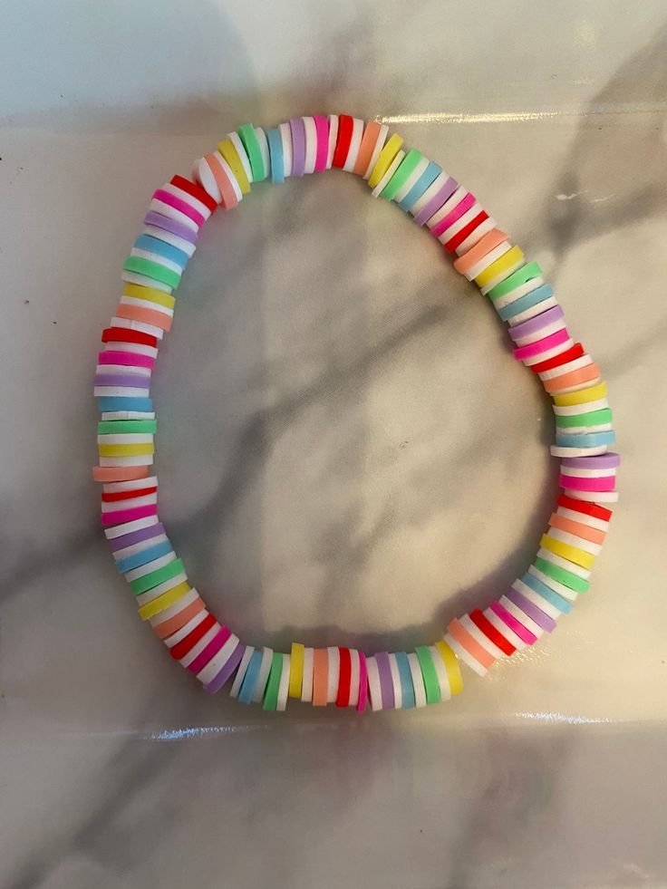 a multicolored bracelet is displayed on a marble countertop in the shape of a circle