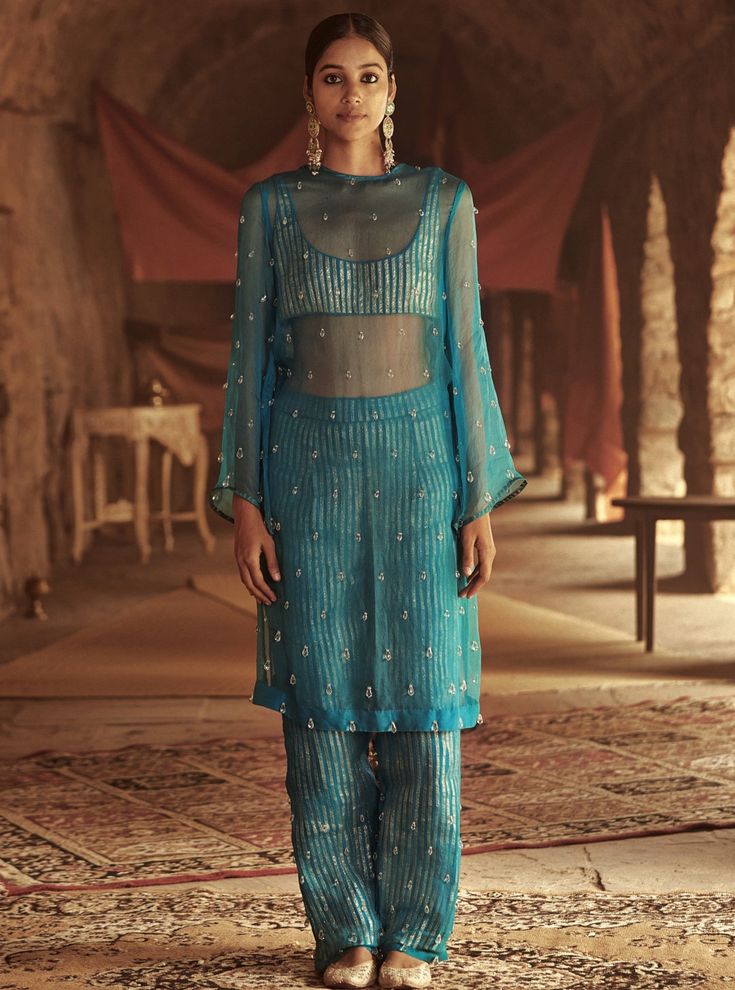 This set features a silk organza kurta adorned with crystals. It comes with a Chanderi crop top embellished with handmade stripes of lampi.The bottom layer of pants has handamde lampi stripes and u... Organza Kurta Set, Organza Kurta, Kurti Pant Set, Kurti Pant, Long Kurti Designs, Kurtis With Pants, Indian Dress, Designer Dresses Indian, Indian Fashion Dresses