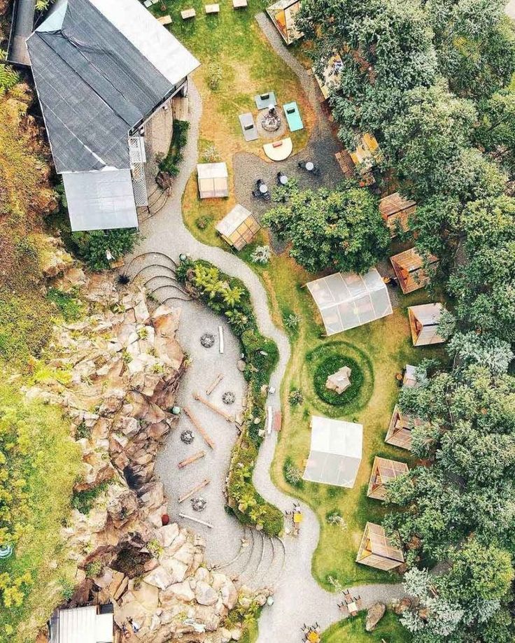 an aerial view of a small village in the middle of some trees and grass area