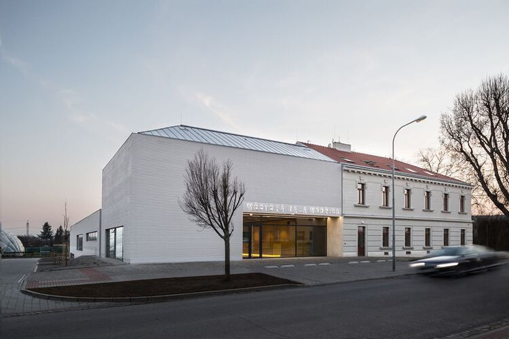 a car is driving past a white building