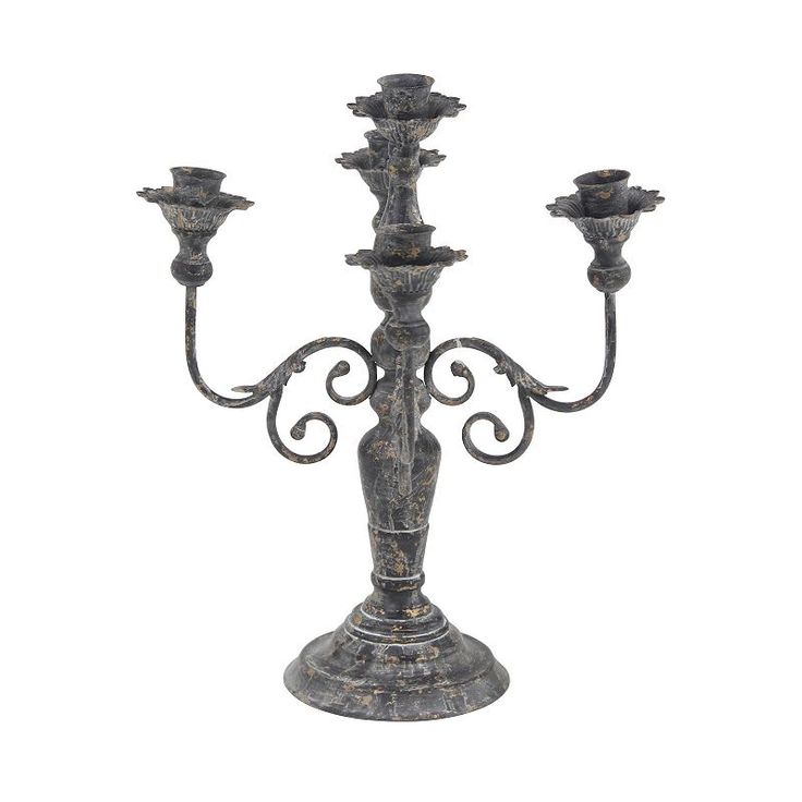 an iron candelabra with three candles on it's stand, isolated against a white background