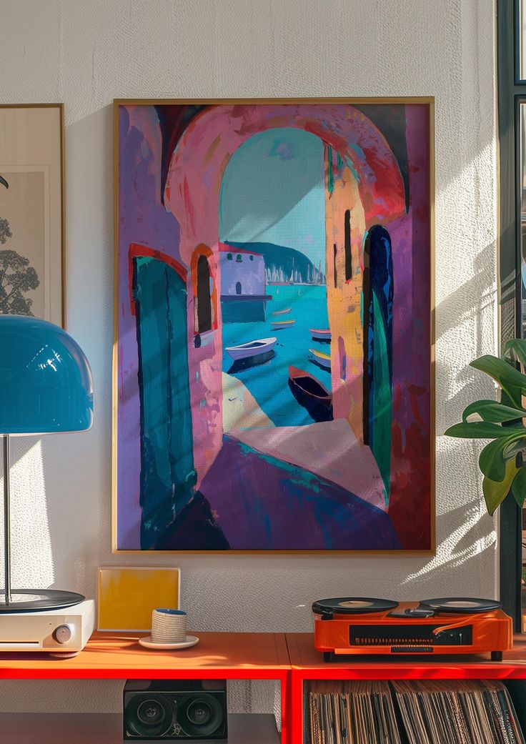 a painting hanging on the wall next to a red table with record player and speakers