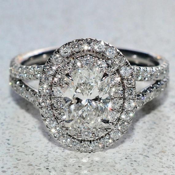 an oval shaped diamond ring with double halos