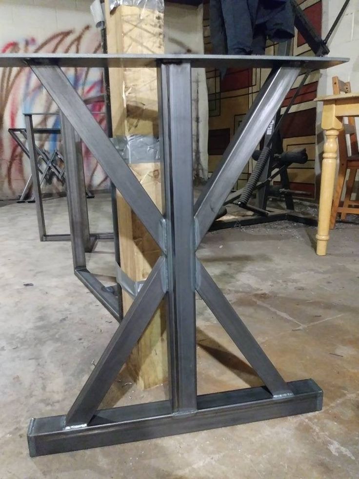 a table that has some kind of metal structure on it's base and is in the process of being assembled