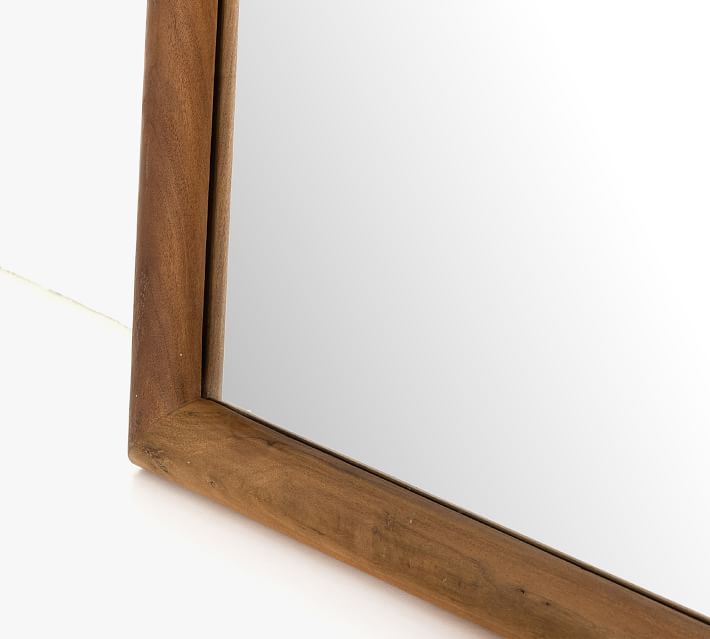 a wooden frame mirror sitting on top of a white floor