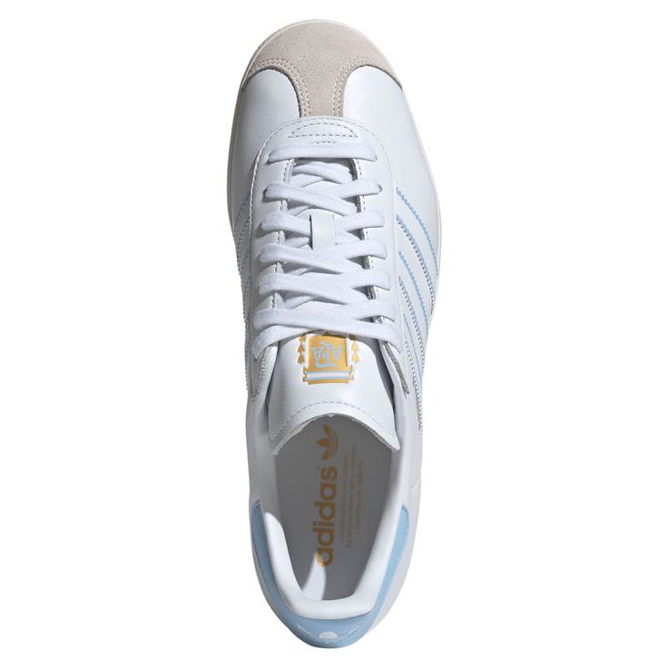 Make your Argentina National Team fandom evident with every step in these Gazelle shoes from adidas Originals. These feature a leather body with suede detailing at the toe. The subtle Argentina National Team design elements allow you to blend your team pride with your everyday look with ease. These are the perfect pair of shoes to wear for every match. Officially licensed Material: 100% Leather - Upper; 100% Rubber - Sole Rubber outsole Brand: adidas Originals Leather upper Wipe clean with a dam Synthetic Slip-on Sneakers With Gum Sole, Adidas Suede Sneakers With Logo, Adidas Suede Sneakers With Round Toe, Adidas Suede Skate Shoes With White Sole, Slip-on Synthetic Sneakers With Gum Sole, Leather Slip-on Skate Shoes With Gum Sole, White Adidas Suede Skate Shoes, Sporty Adidas Leather Skate Shoes, White Suede Adidas Skate Shoes