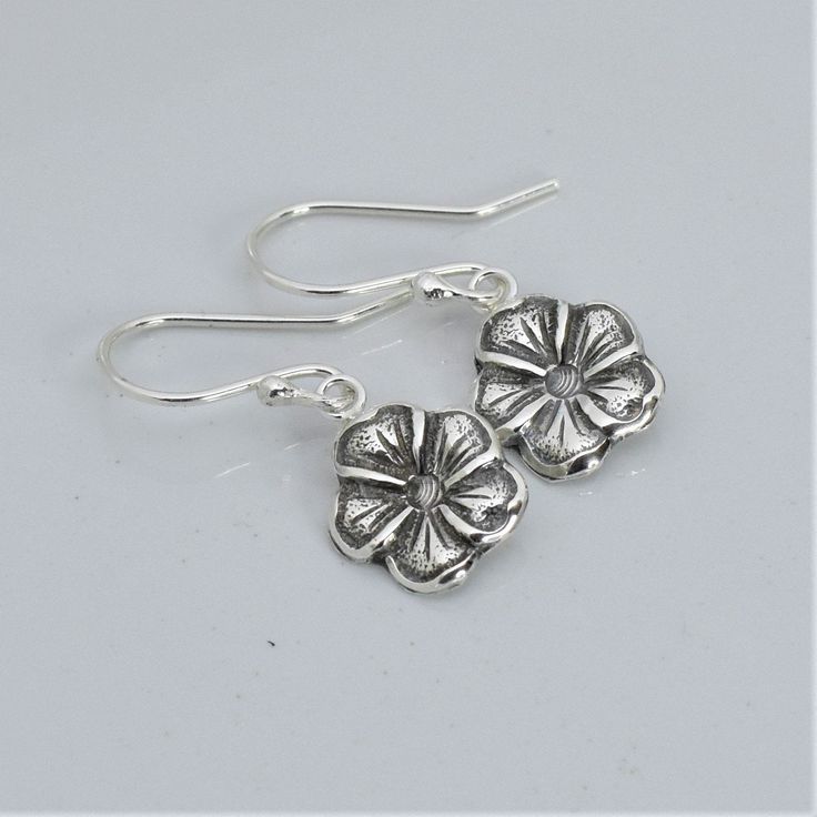 Artisan handmade sterling silver earrings with antiqued finish. Forget me not flower is a symbol of remembrance of a loved one lost. It also symbolizes fidelity, truthfulness, respect and true love. Perfect gift for any woman on her birthday, Mother's Day, anniversary, Christmas holidays, etc. * Dangle length approximately 1 inch * Handcrafted from sheet metal with steel die reproductions and hydraulic press * Antiqued Finish .925 Sterling Silver * Boxed in simple Kraft cotton filled box with ri Delicate Silver Flower Earrings Nickel Free, Silver Pierced Flower Earrings For Gift, Delicate Silver Flower Earrings Nickel-free, Delicate Silver Nickel-free Flower Earrings, Silver Nickel-free Flower Earrings For Anniversary, Silver Delicate Nickel-free Flower Earrings, Silver Flower Earrings For Gift, Silver Drop Flower Earrings Gift, Silver Flower Pendant Jewelry With Matching Earrings