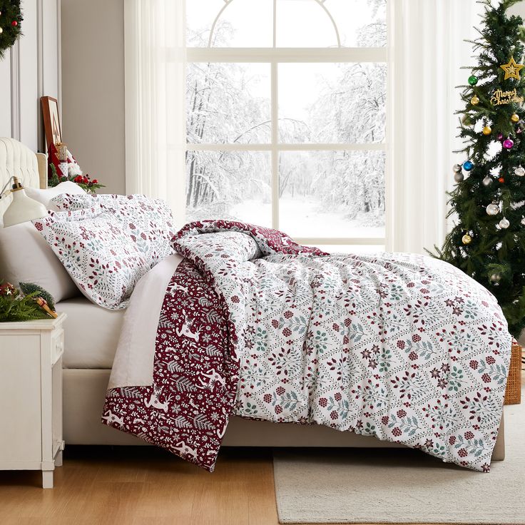 a white bed sitting next to a window covered in christmas decorations