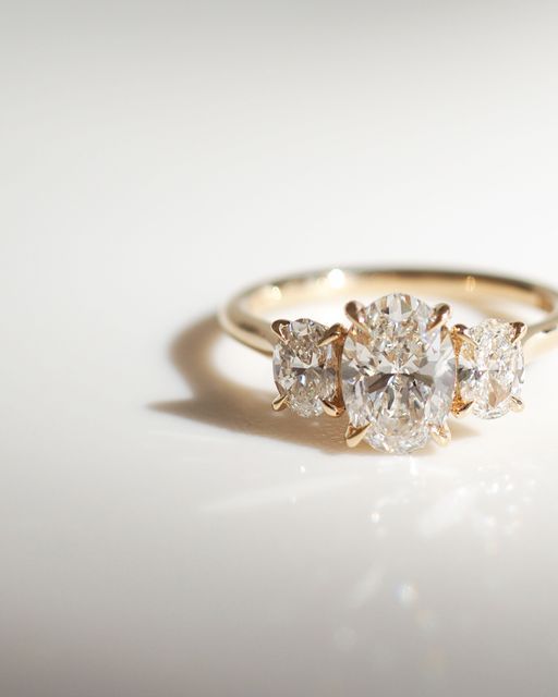 three stone diamond ring on white surface