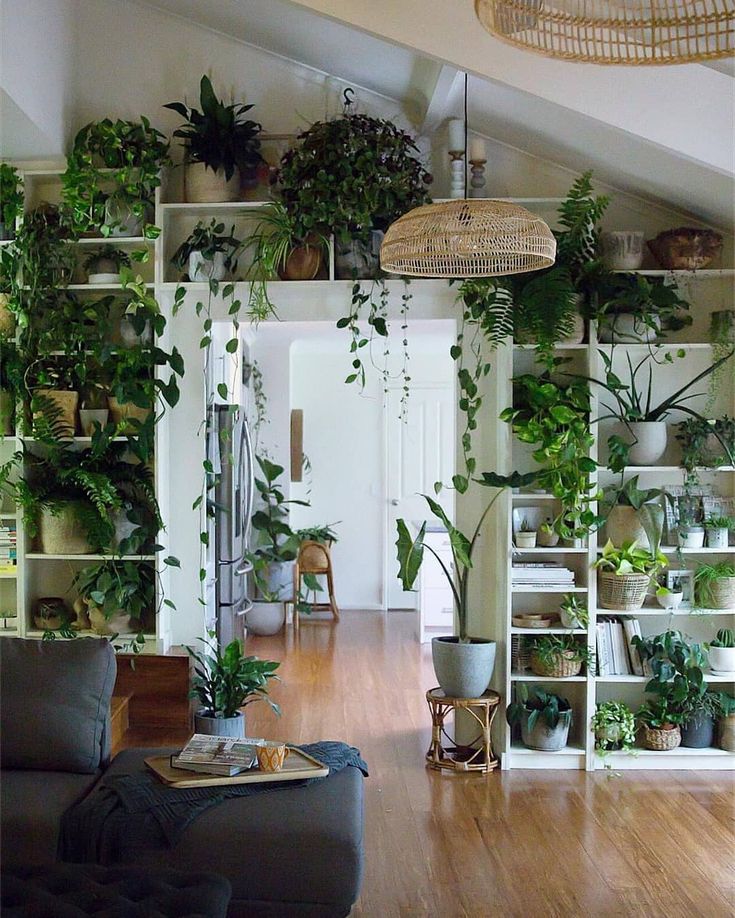 a green table topped with potted plants next to a wooden bench in a living room