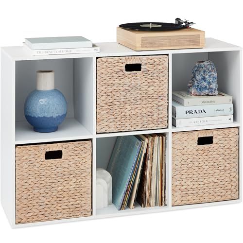 a white shelf with four baskets and a record player