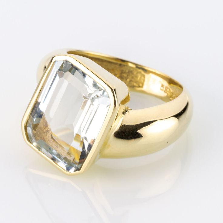 This ring is a unique piece of jewelry that enhances any look with its impressive presence and is sure to turn heads. The artistic design of the ring is perfectly matched to the large 10-carat gemstone, showcasing it impressively. A one-of-a-kind piece that adds grandeur to any outfit with its imposing presence. Metal 14k / 0.585 gold Gemstones 1 aquamarine 10.0ct Measurements Head 16.6mm Shank 5.8mm Ring size 7 US Weight 11.4g Condition Pre-owned, excellent condition   General Information All i Modern Yellow Gold Blue Topaz Ring, Modern Emerald Cut Topaz Ring For Wedding, Timeless Blue Topaz Ring, Modern 14k Gold Emerald Cut Topaz Ring, Modern Gold Blue Topaz Ring, Timeless Blue Topaz Gemstone Ring, Modern Octagon Topaz Gemstone Ring, Modern Octagon Topaz Ring, Modern Gold Rings With Blue Topaz