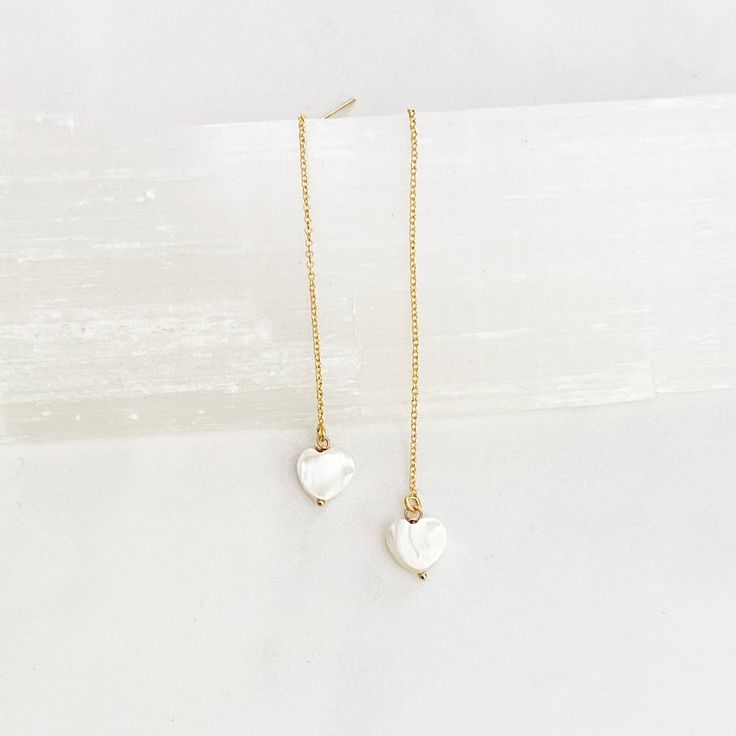 These super cool earrings are versatile and lightweight. They feature a tiny 8mm white mother of pearl hand carved heart that dangles from 3” of 14kt gold filled threader chain including the post. Simply push the post through the pierced hole and pull through to desired length. They come with a rubber stopper so can also be worn as a long dangle post earring once the stopper is put on the post. Cool Earrings, Carved Heart, Pearl Heart, Pull Through, Threader Earrings, 14kt Gold, Post Earrings, Mother Of Pearl, Gold Filled