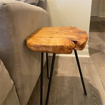 a wooden table sitting on top of a hard wood floor next to a gray couch