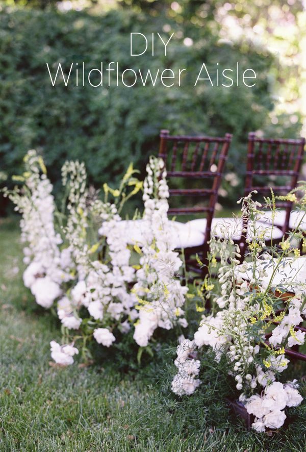 there are many chairs lined up in the grass with flowers growing on them and one chair is empty