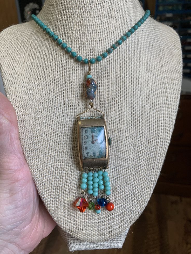 "~ I made this set and fell in love with it. It is one of my favorite pieces. It is made of an vintage (man's) watch face (non working). Inside the watch is patina, which is a green color and was the inspiration in my color choices. I added clear seed beads and a beautiful art glass bead at the top. All the beads are vintage and glass. On the bottom of the necklace I hung several turquoise colored beads and a different color and kind off each section. The chain is also vintage, maybe from the 80 1950s Man, Teal Glass, Face Necklace, Assemblage Jewelry, Metal Ball, Red Bead, Upcycled Vintage, Watch Necklace, Turquoise Color