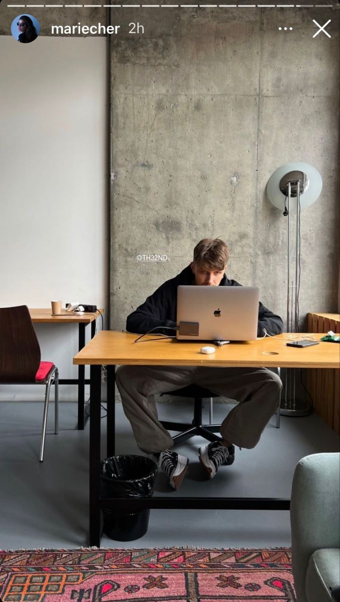 a man sitting at a desk using a laptop computer